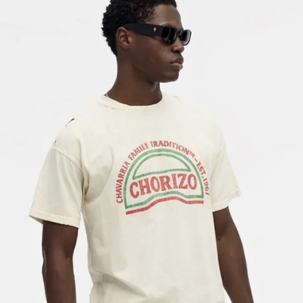 Model wearing an off-white graphic T-shirt with red and green “Chorizo” print, styled with black rectangular sunglasses, presented against a clean neutral background for new arrivals at ELLIS ROSCH menswear.