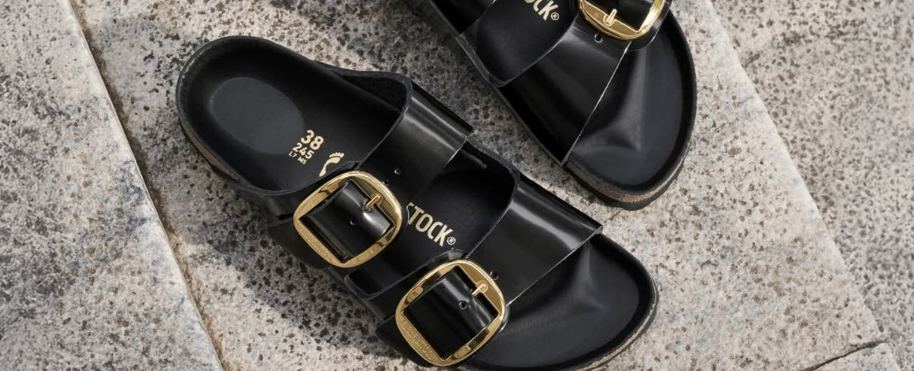 Birkenstock black leather sandals featuring signature double-buckle design, combining timeless craftsmanship, everyday comfort, and a modern approach to functional luxury footwear.
