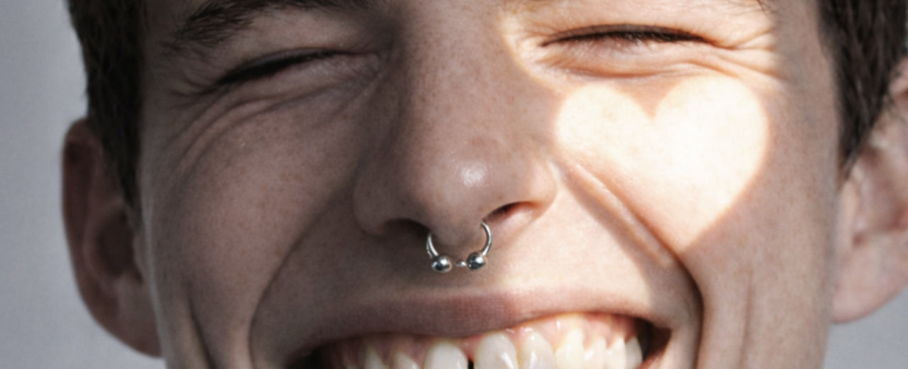 Close-up of a smiling face with eyes closed, soft heart-shaped light on the skin, conveying warmth, intimacy, and the feeling of a premium gift chosen for someone you love.