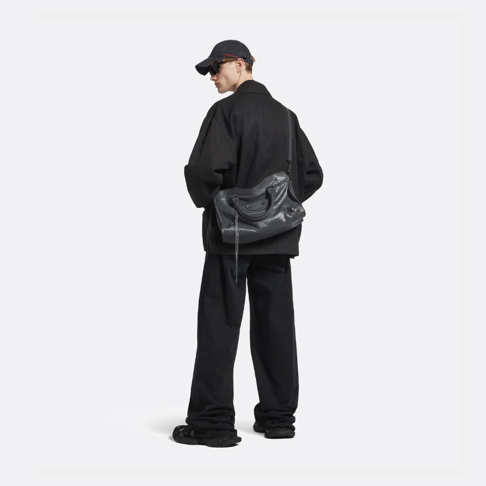 Modern luxury everyday styling featuring a relaxed black silhouette with oversized tailoring and a leather crossbody bag, expressing a contemporary, minimalist approach to designer fashion.